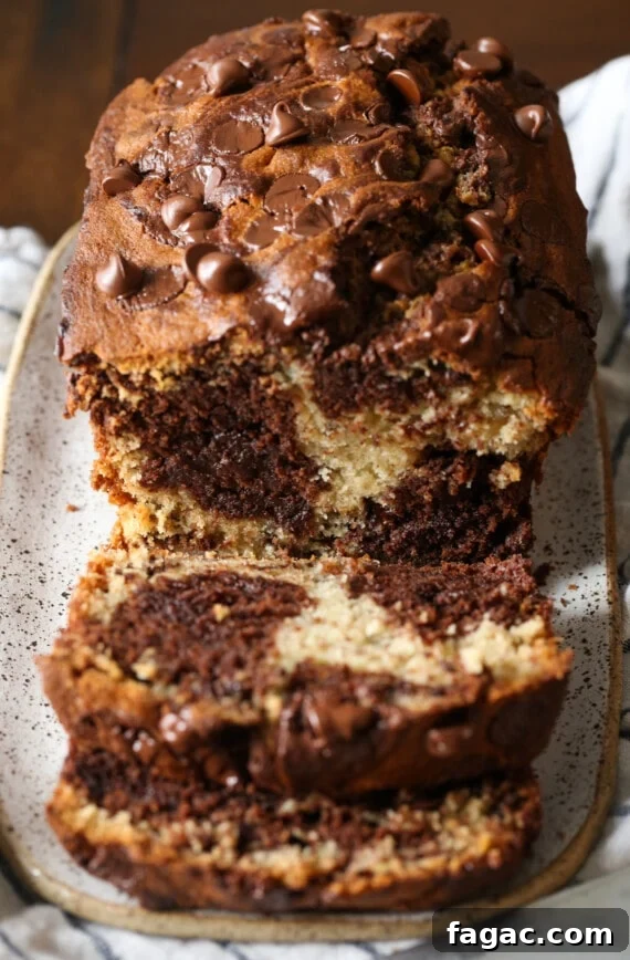 Chocolate Marble Banana Bread Recipe 9 A loaf of chocolate marbled banana bread sliced to reveal the marbled interior.