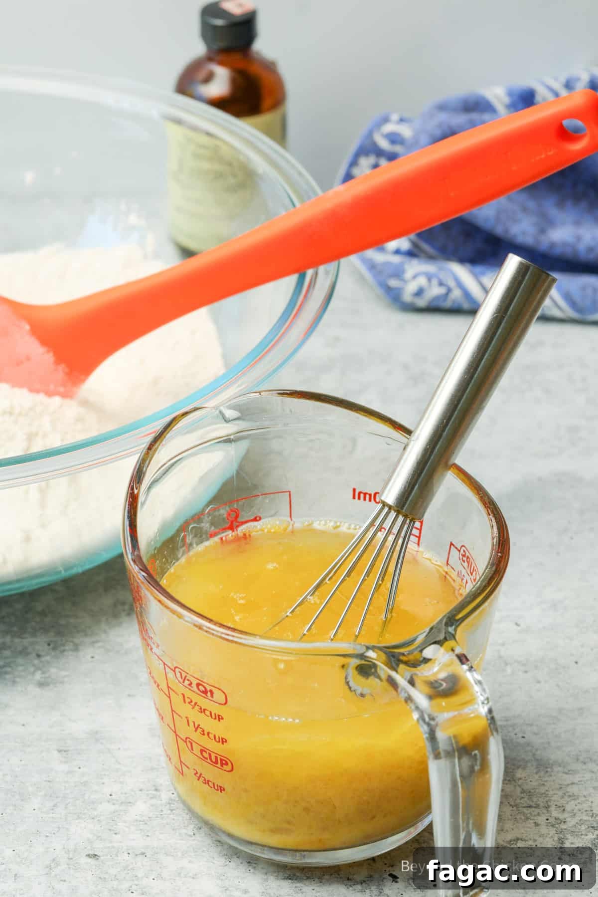 Moist Carrot Cake Recipe with Cream Cheese Frosting 5 Egg and oil combined in a glass measuring cup with a whisk.