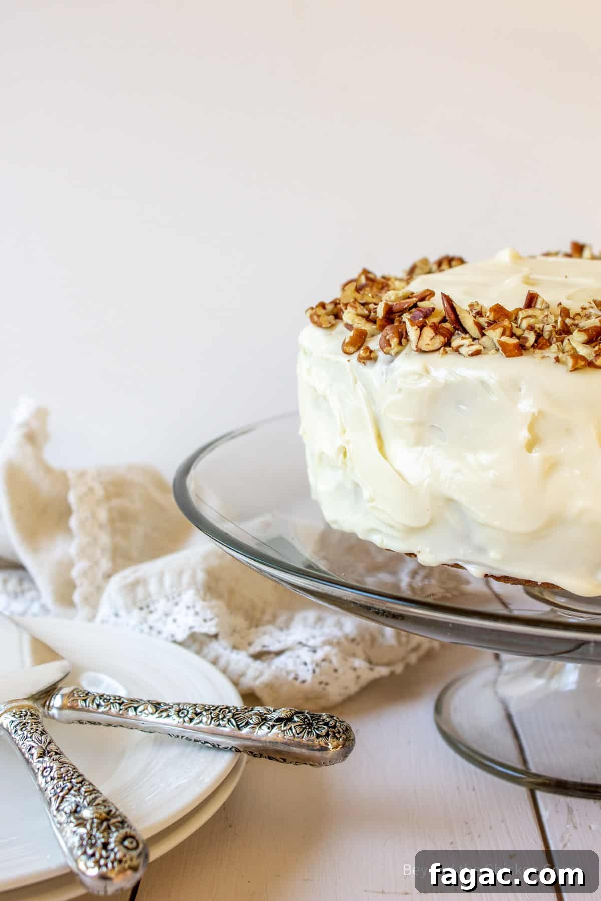 Moist Carrot Cake Recipe with Cream Cheese Frosting 9 A layered carrot cake topped with cream cheese frosting and pecans.