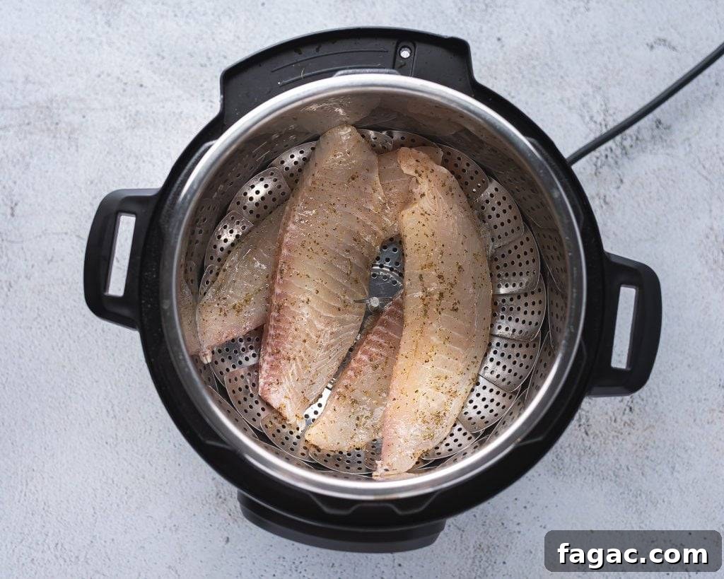 Instant pot with raw tilapia fillets on a steamer basket