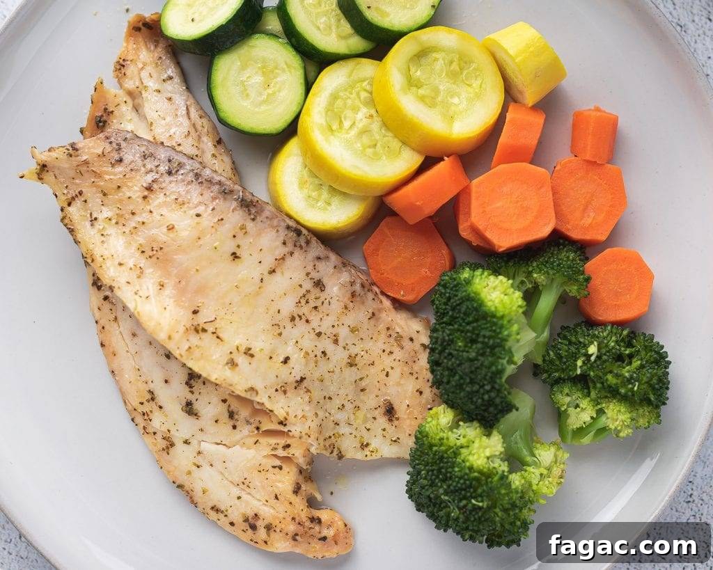 white plate with instant pot tilapia, broccoli, carrots and squash