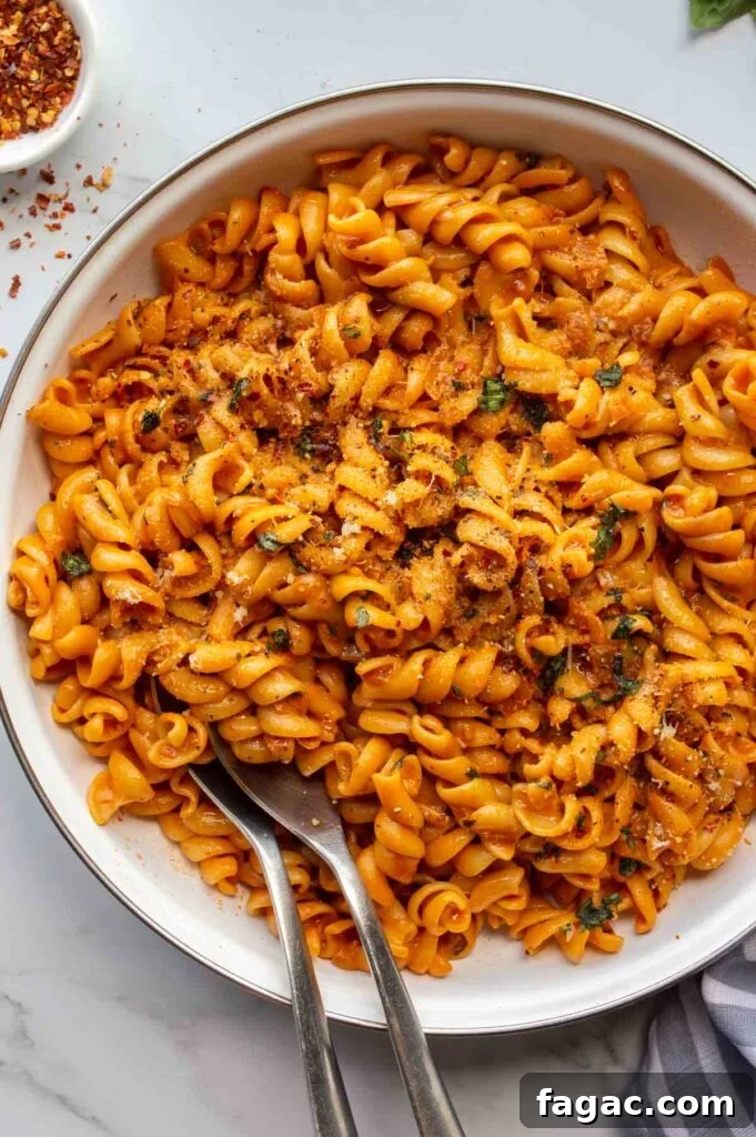 20-Minute Creamy Vegan Tomato Pasta Recipe 2 white pan with orange saucy pasta on a white background.