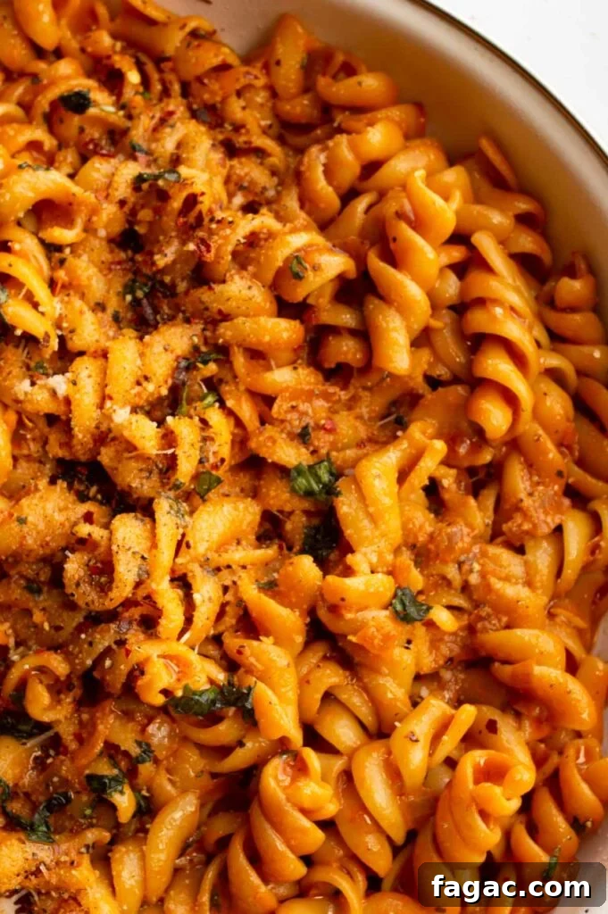20-Minute Creamy Vegan Tomato Pasta Recipe 4 Closeup overhead of pasta coated in a creamy orange sauce.