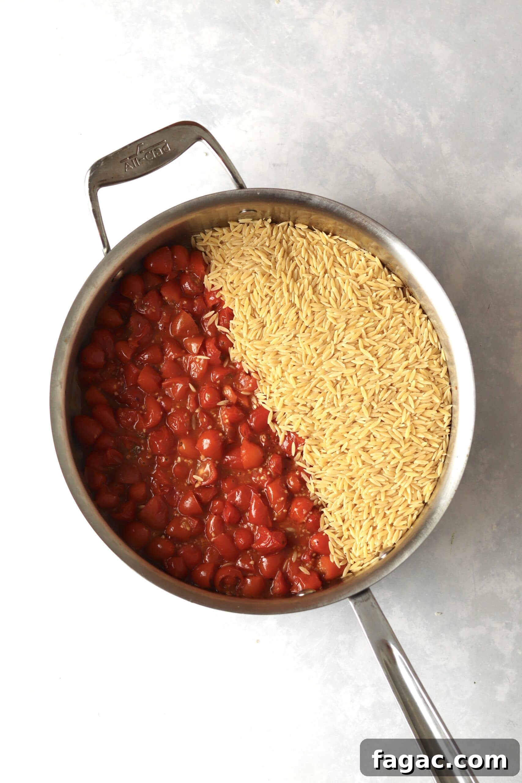One-Pot Shrimp and Tomato Orzo with Garlic and Basil 5 cooked grape tomatoes and uncooked orzo in pan.