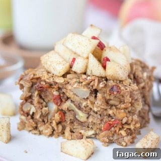 Apple Cinnamon Baked Oatmeal Recipe for Warm Fall Breakfast 7 Slice of apple cinnamon baked oatmeal topped with slices of fresh apples served on a plate