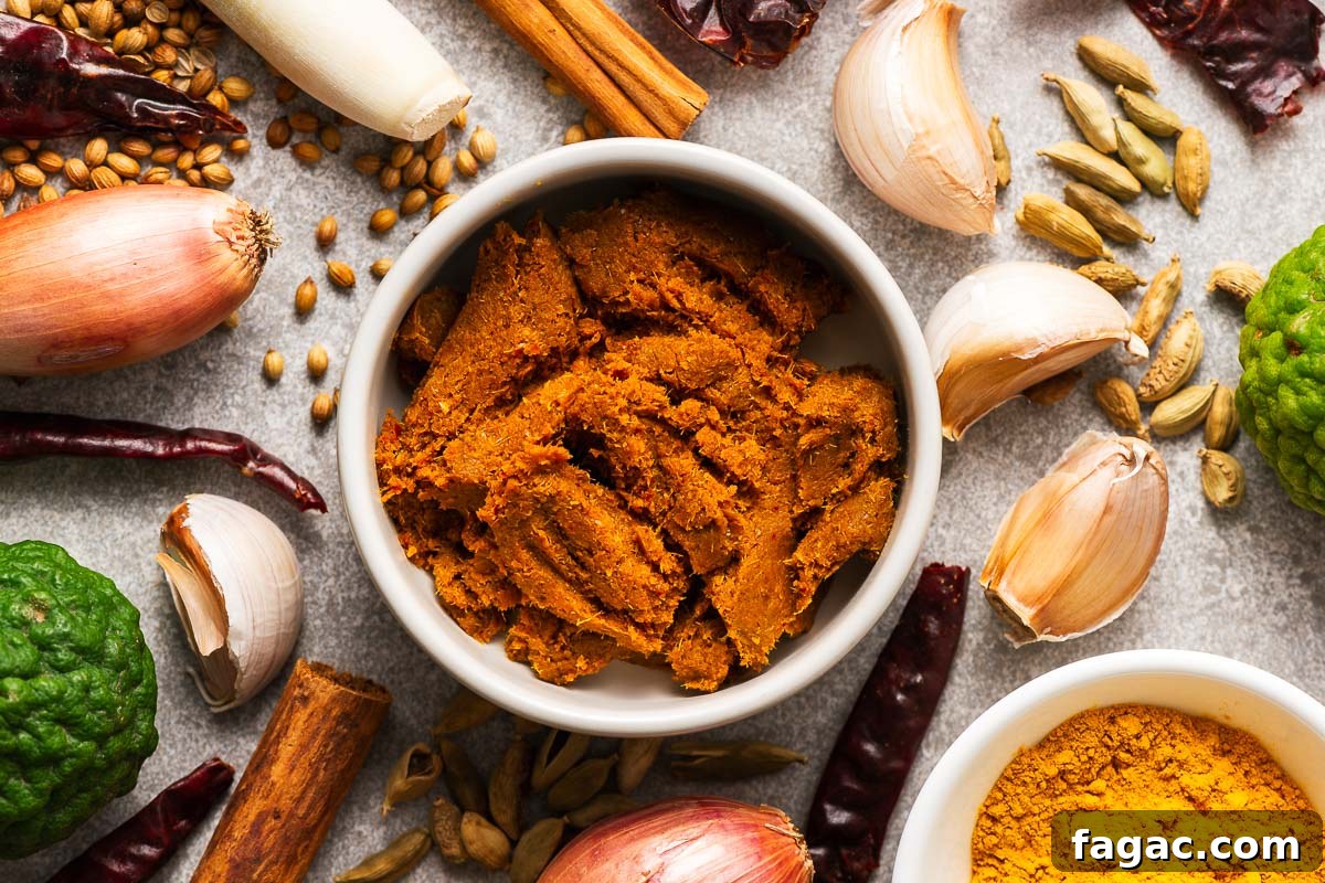 Thai Red Curry Paste Substitutes: What to Use and What to Avoid 5 A bowl with Thai yellow curry paste surrounded by key ingredients like dried red chillies, kaffir lime, lemongrass, garlic, shallots, and spices like turmeric, curry powder, coriander seeds, and cinnamon.