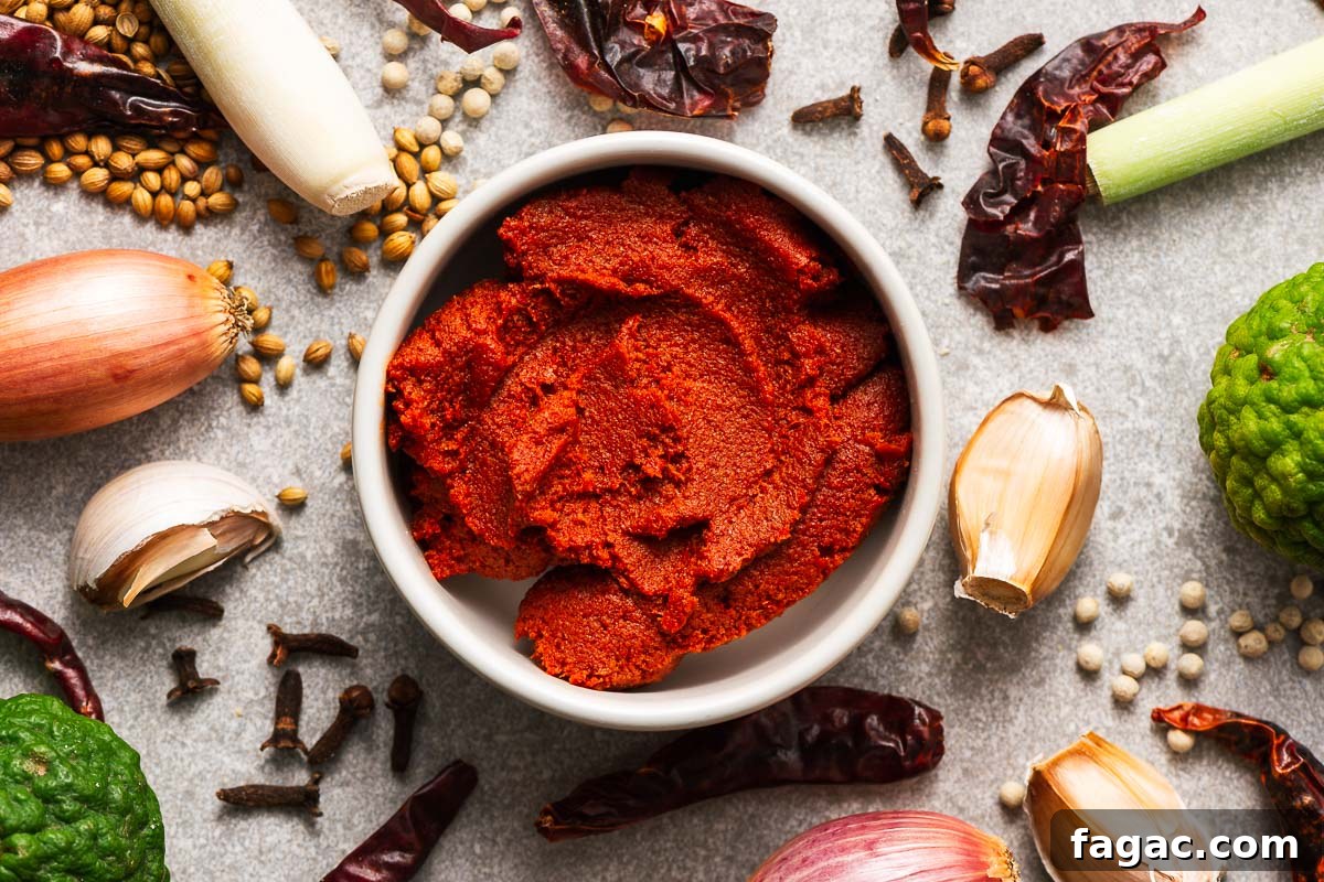 Thai Red Curry Paste Substitutes: What to Use and What to Avoid 6 A bowl with Massaman curry paste surrounded by key ingredients like dried red chillies, kaffir lime, lemongrass, garlic, shallot, coriander seeds, and cloves.