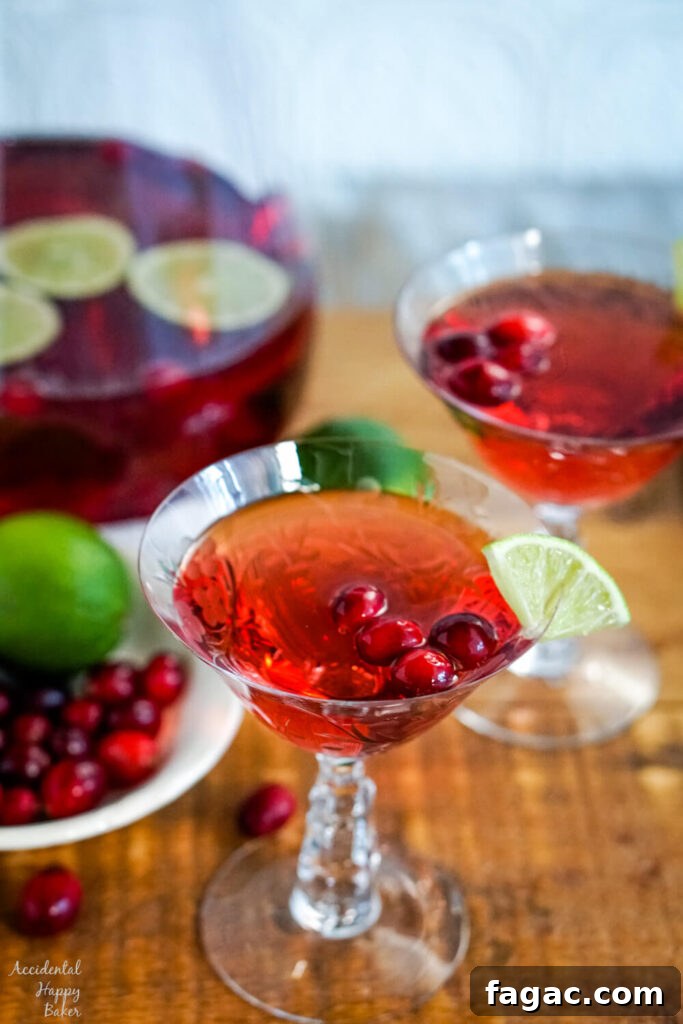 A glass of cranberry moscato punch on a wooden serving tray.