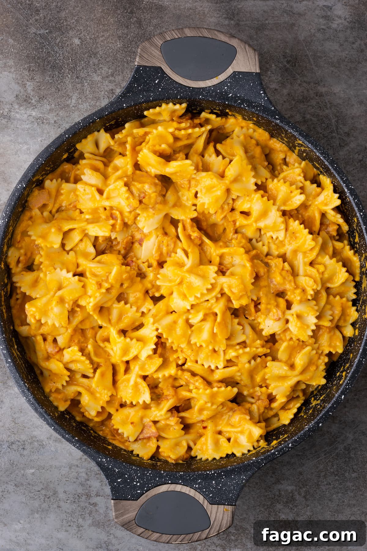 Finished pumpkin pasta with bacon in a large cast iron skillet.