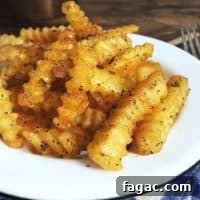 Crispy Frozen French Fries: Oven & Air Fryer Methods for Perfect Results 5 Crispy golden fries on a white plate for how to cook frozen fries