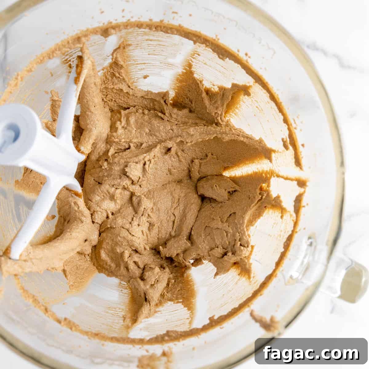 Whipped butter and brown sugar in a mixing bowl with a paddle attachment