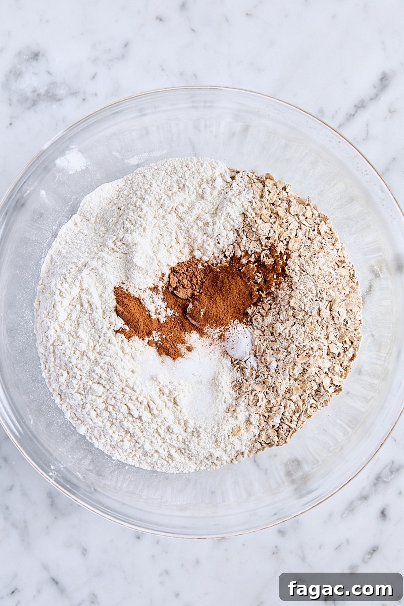 Chewy Homemade Iced Oatmeal Cookies Recipe 7 Coarsely ground oats, flour, baking powder, baking soda, cornstarch, salt, cinnamon, and nutmeg in glass bowl