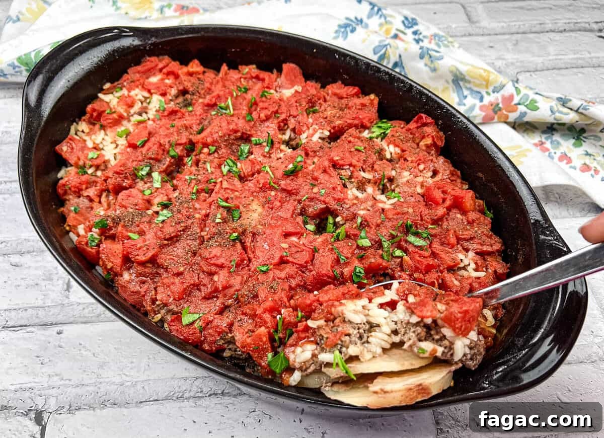 23 Classic Casseroles That Taste Like Grandma’s Comfort Cooking 6 Shipwreck Casserole in a black dish with a spoon.