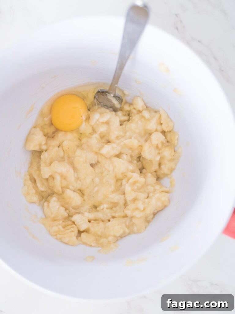 egg with mashed bananas in a mixing bowl