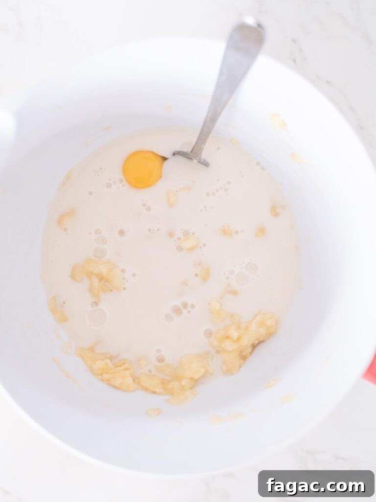 almond milk added to the bananas and egg in a mixing bowl