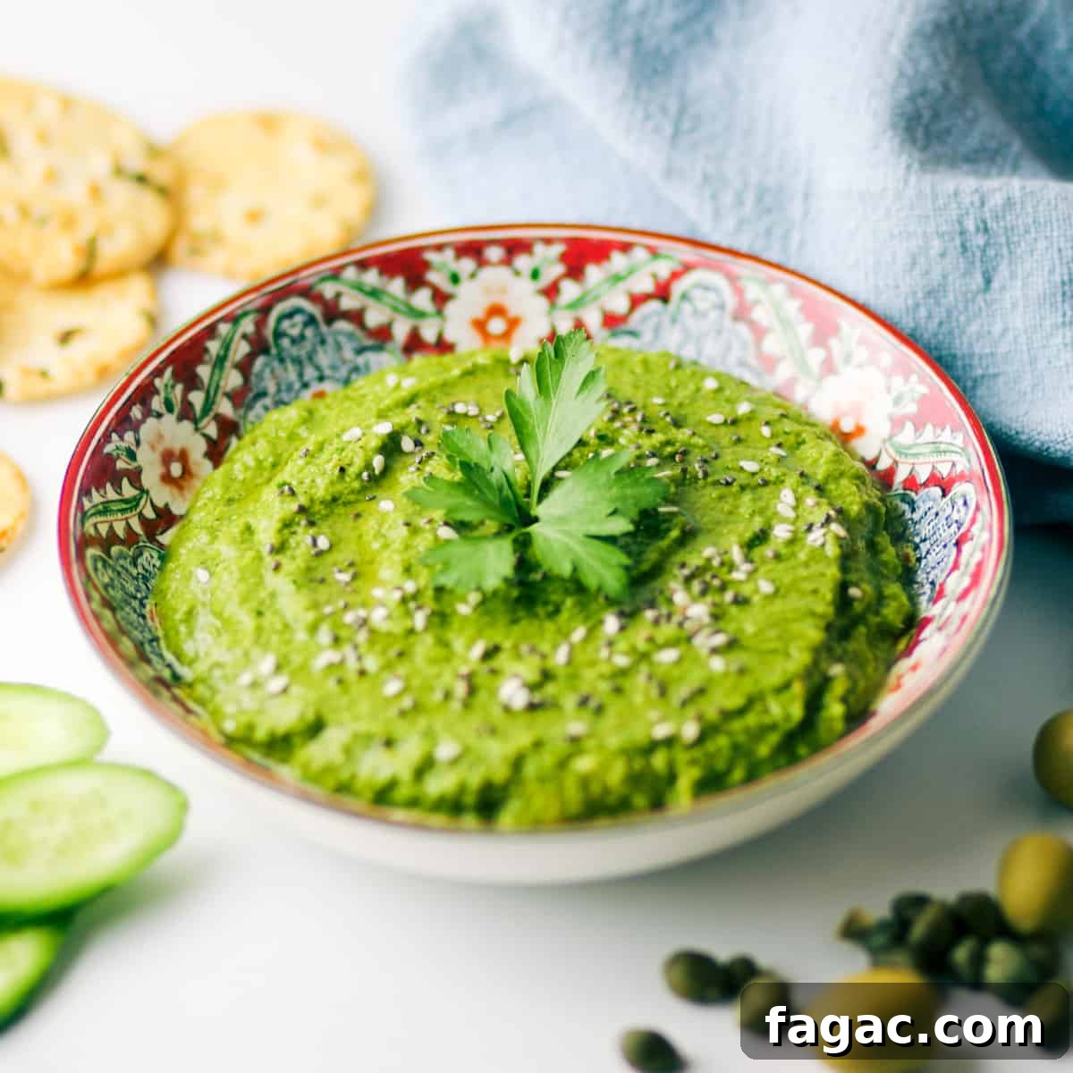 Dish of Zingy Green Olive Tapenade with ingredients surrounding it.