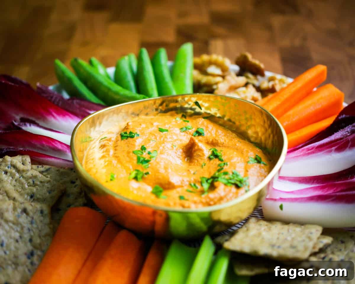 Photo of a brass bowl of speedy muhummara with crudites and crackers surrounding it