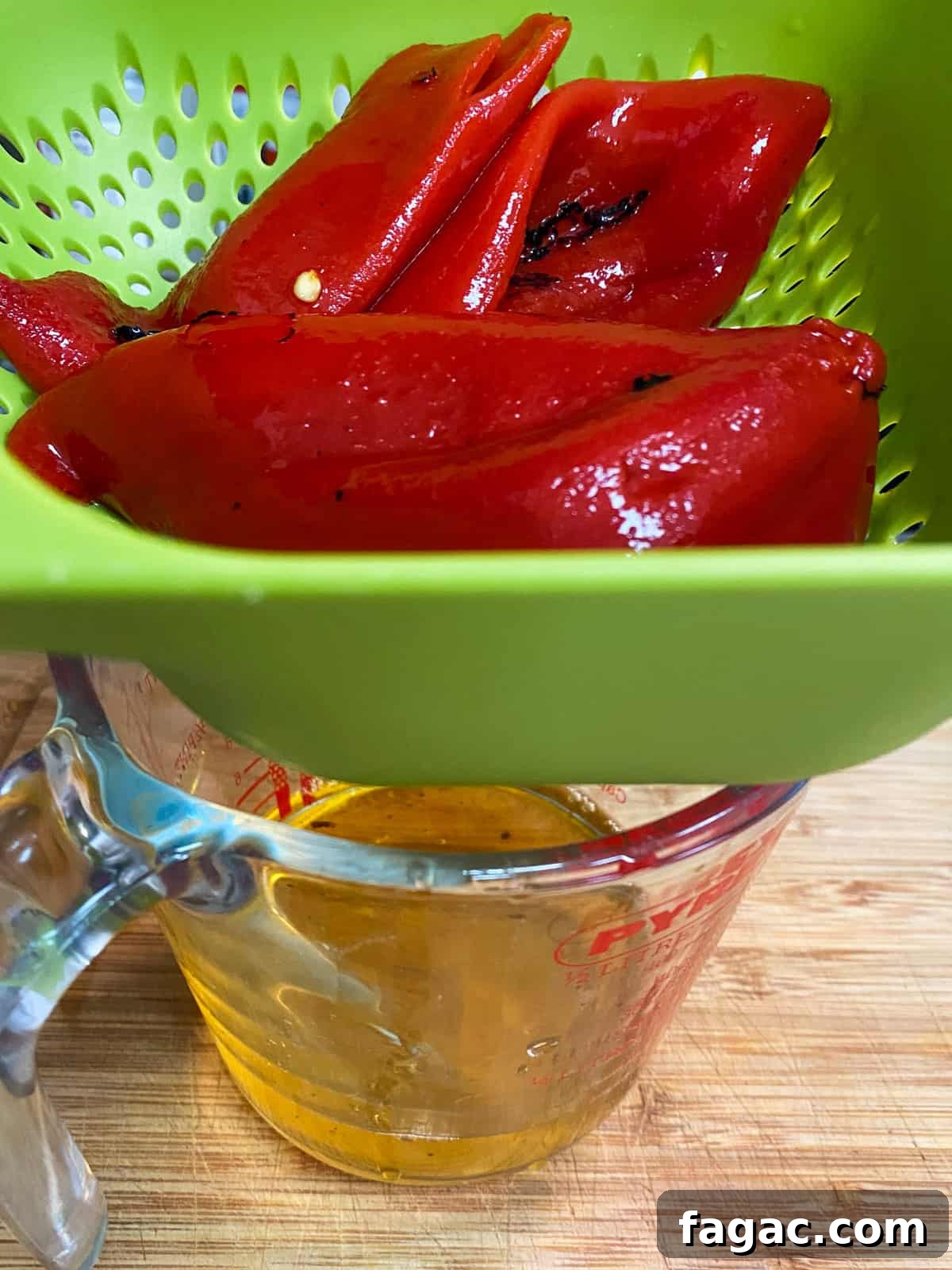 photo of jarred roasted red peppers being drained in a colander over a jug.
