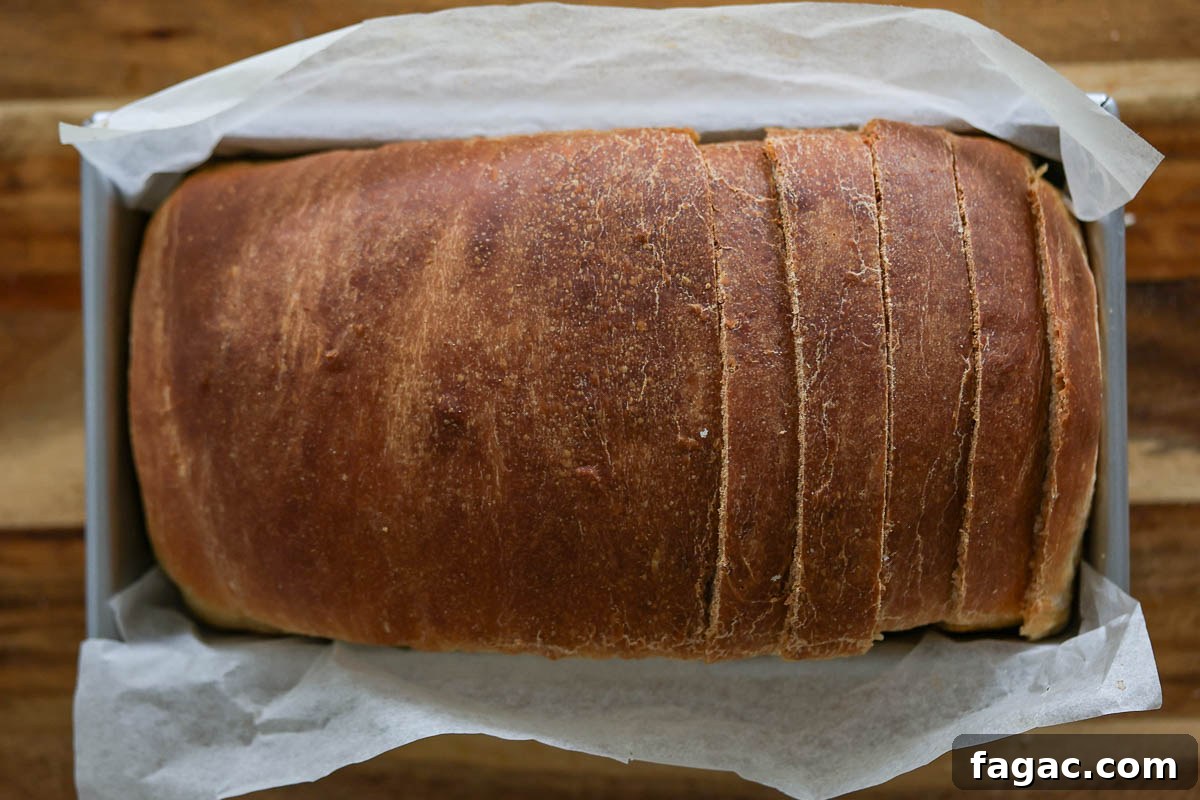 Sourdough Buttermilk Bread Recipe: Tangy Artisan Loaf Guide 13 Sourdough buttermilk bread, sliced, inside a loaf pan with parchment paper.