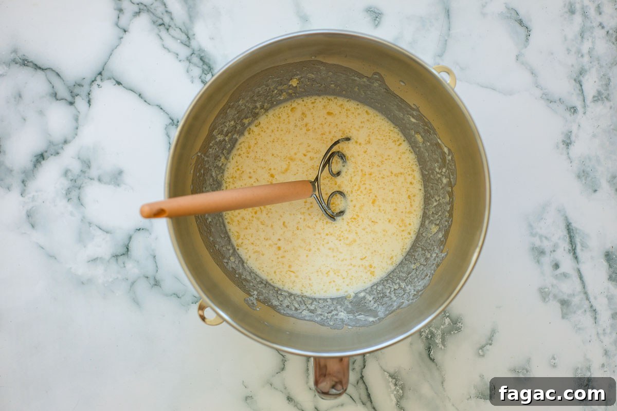 Sourdough Buttermilk Bread Recipe: Tangy Artisan Loaf Guide 4 Wet dough ingredients in a metal bowl with dough mixer.