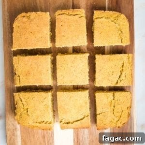 Gluten-Free Vegan Cornbread Made with Pureed Corn Kernels 14 square cornbread, on a wooden board, cut into 9 even slices.
