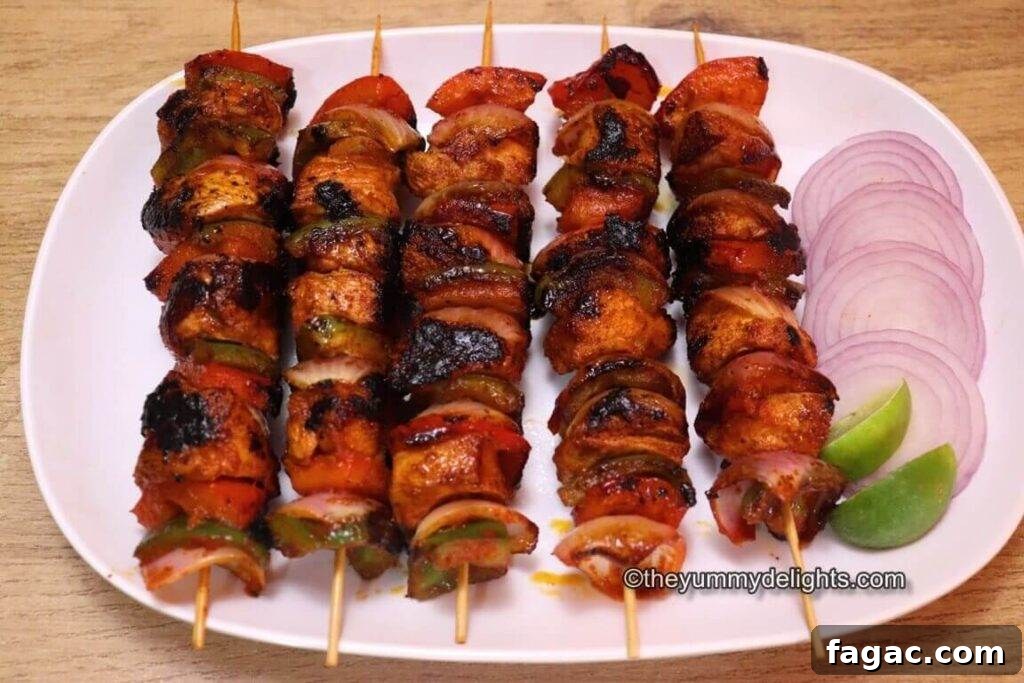 Chicken Shashlik Kebab Recipe: Juicy Grilled Indian-Style Skewers 6 Close-up image of 5 shashlik kebabs served on a white plate with onion slices and lemon wedges.