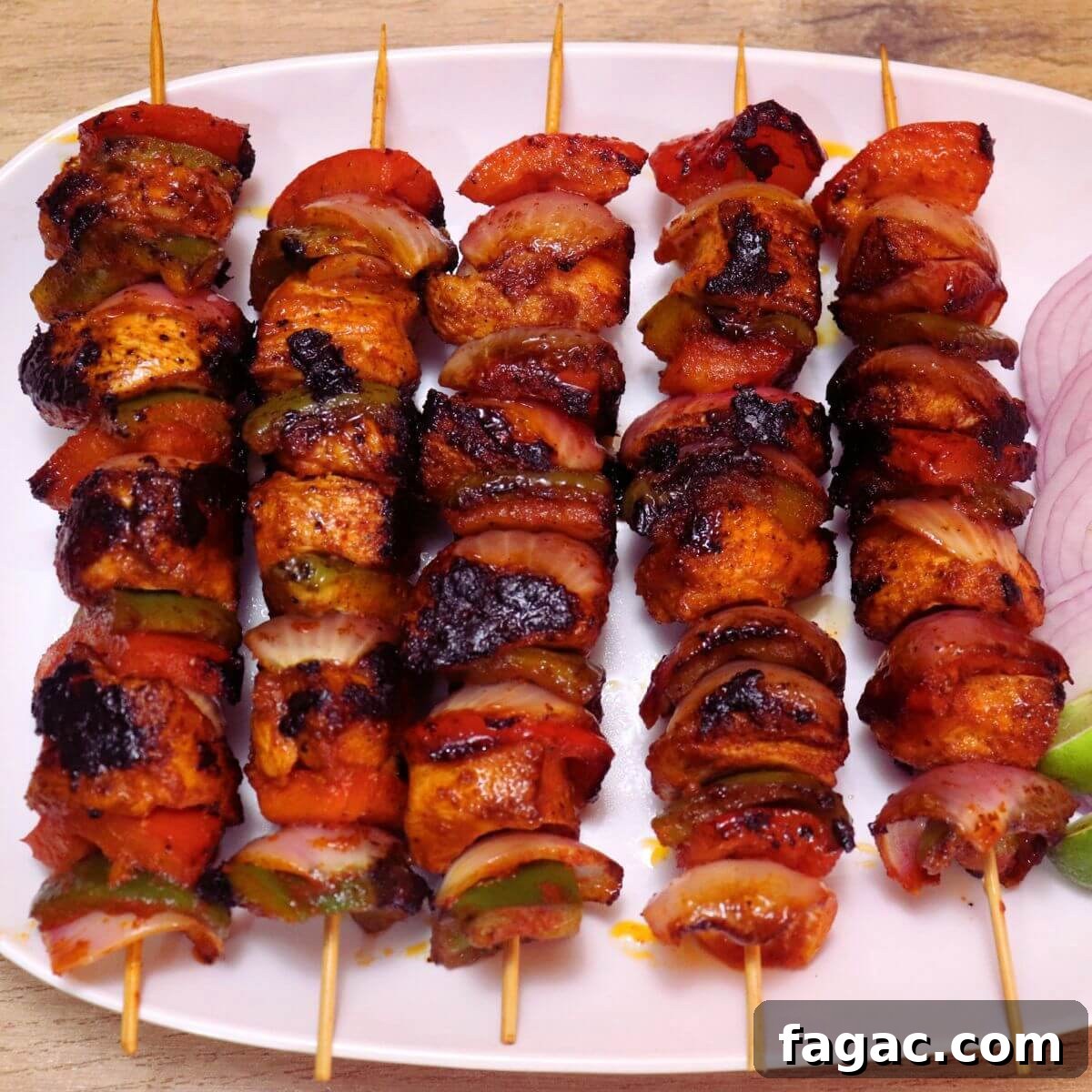 Chicken Shashlik Kebab Recipe: Juicy Grilled Indian-Style Skewers 7 skewered chicken shashlik served on a white plate.