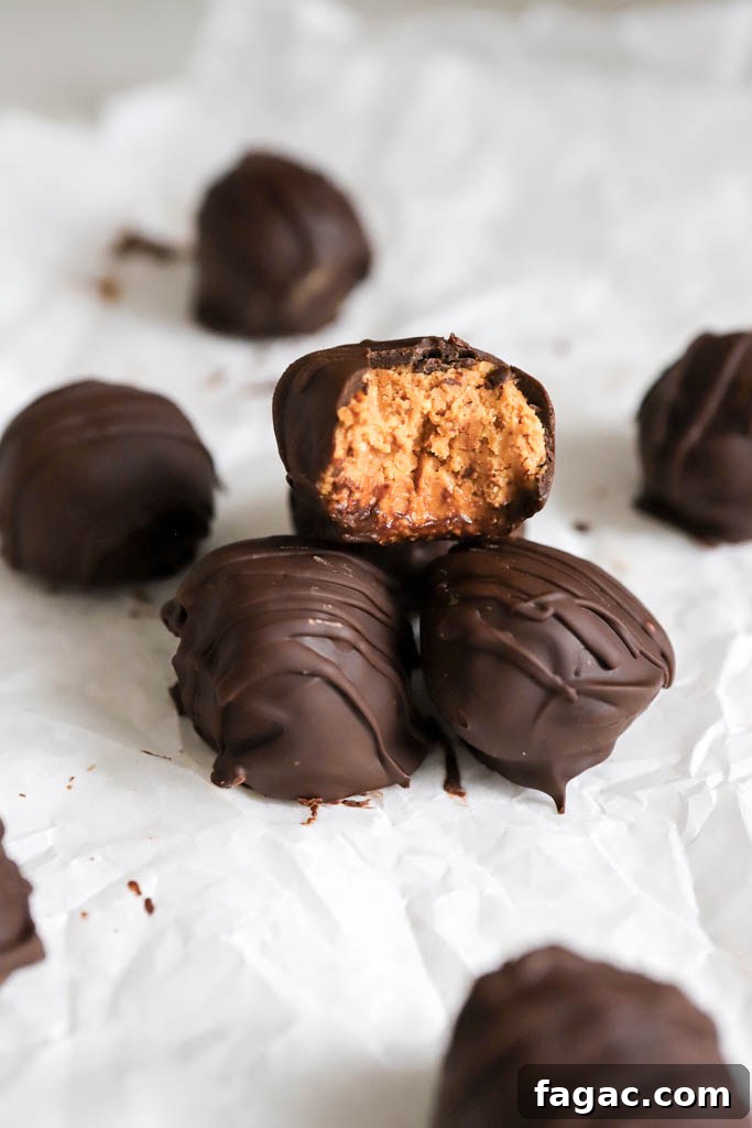 No-Bake Peanut Butter Graham Balls — 5 Ingredients 2 melted chocolate on peanut butter balls recipe on parchment paper