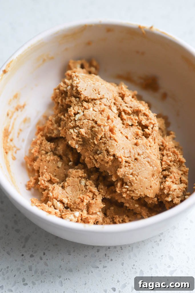 No-Bake Peanut Butter Graham Balls — 5 Ingredients 6 Small white bowl with a dough mixture inside.