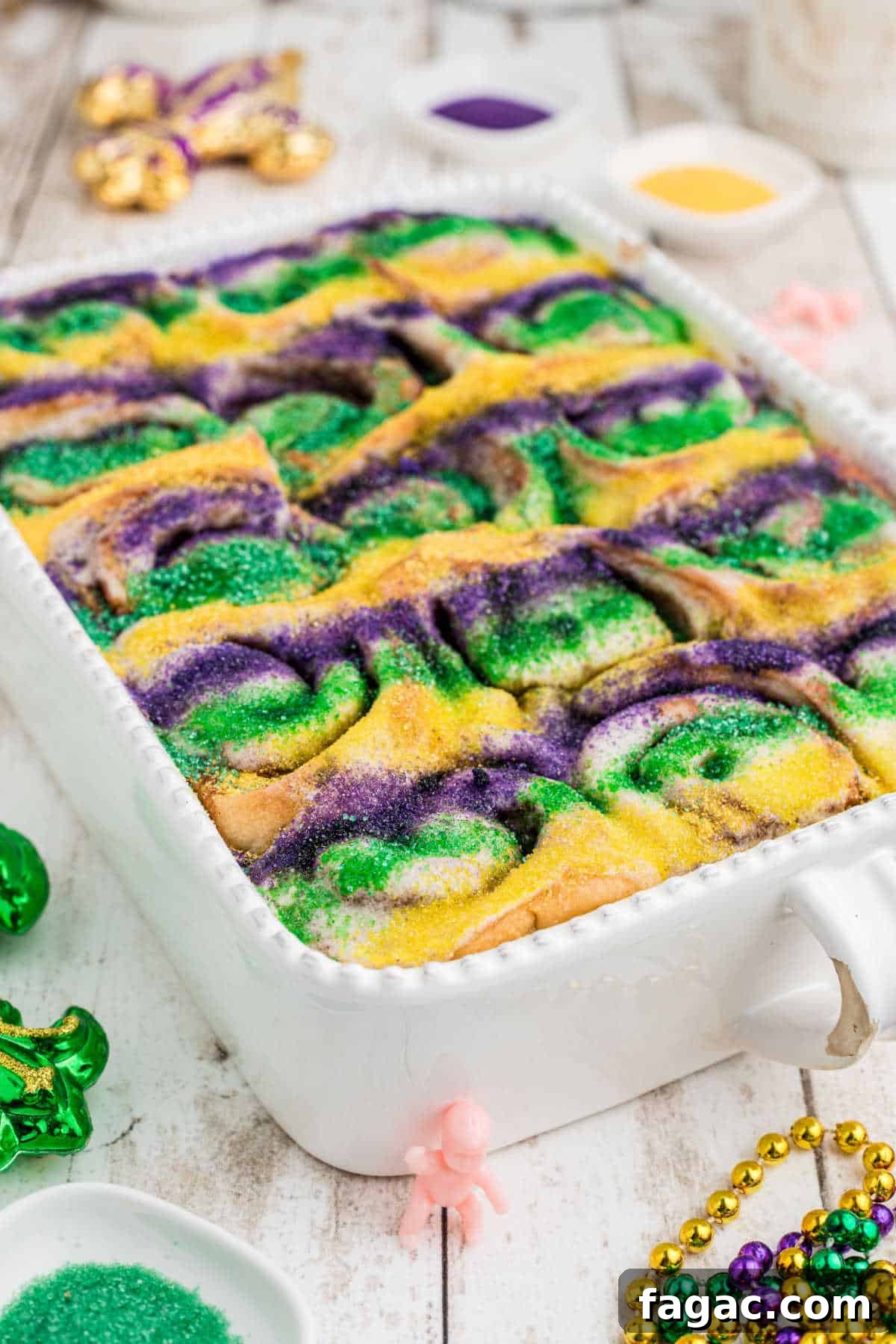King Cake Cinnamon Roll Recipe: Sweet New Orleans Breakfast 11 Side shot on an angle of a dish full of king cake cinnamon rolls.