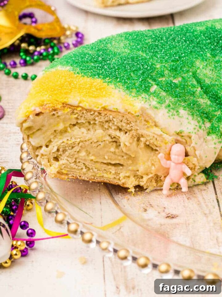 a king cake with a piece cut out with the king cake baby sitting there