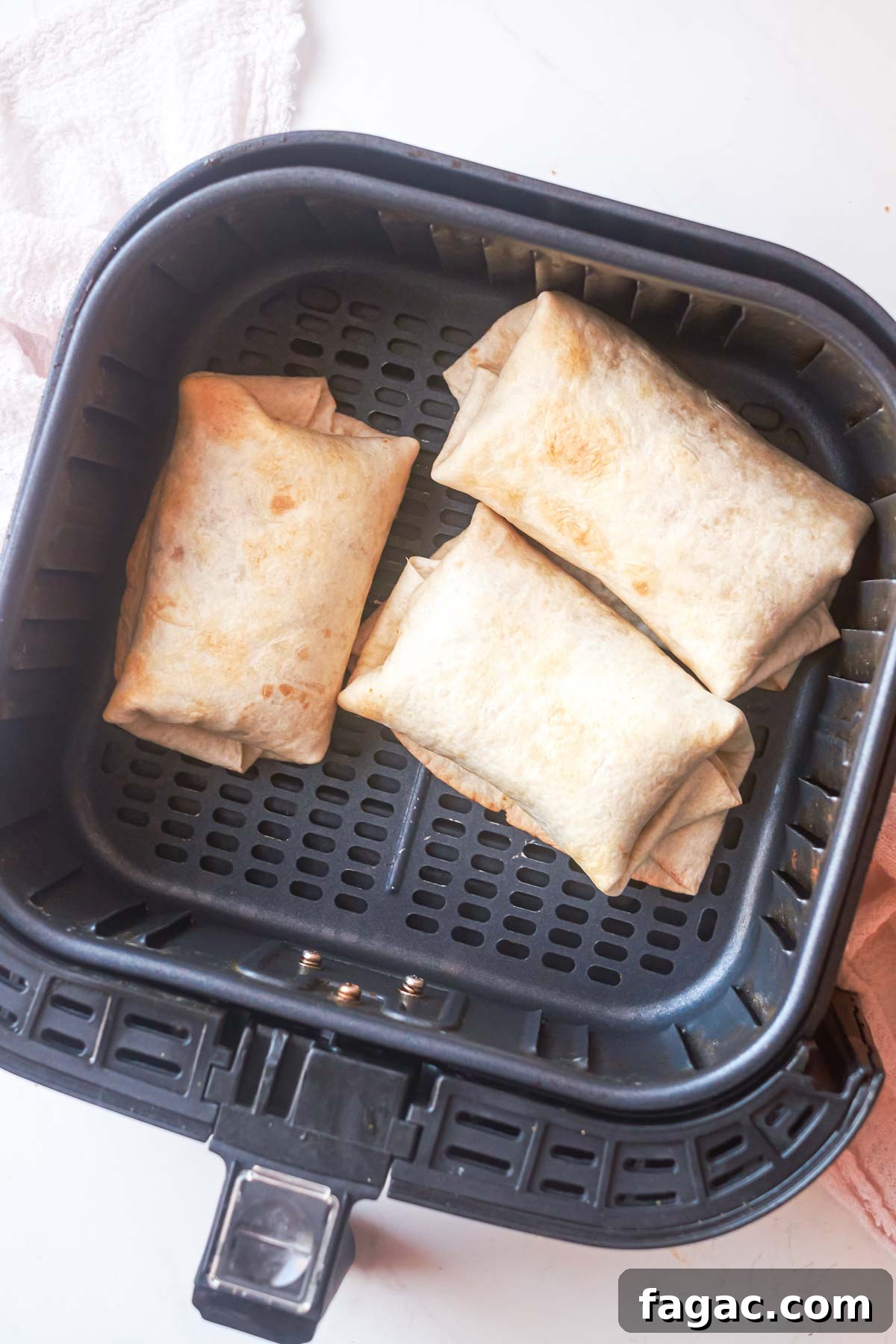 Crispy Air Fryer Breakfast Burrito Recipe 7 top down view of 3 air fryer burritos inside the air fryer basket