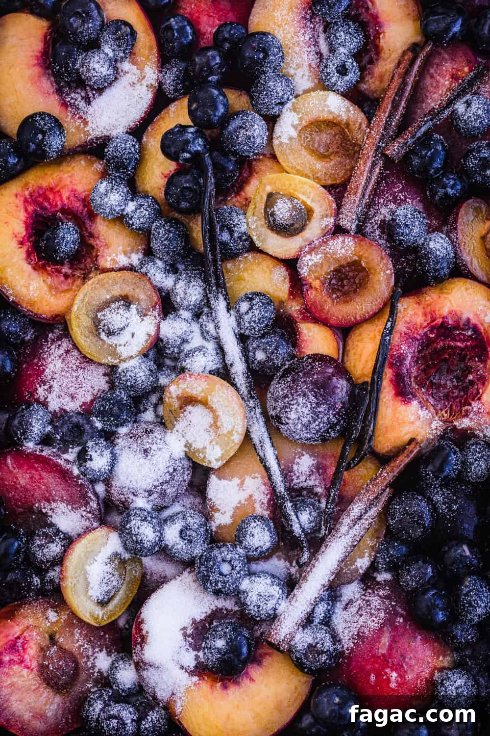 Cooked Fruit: Baked, Roasted, Poached and More 2 raw stone fruit with blueberries, vanilla beans, cinnamon and sugar on a baking sheet and all ready to go in the oven and be cooked.