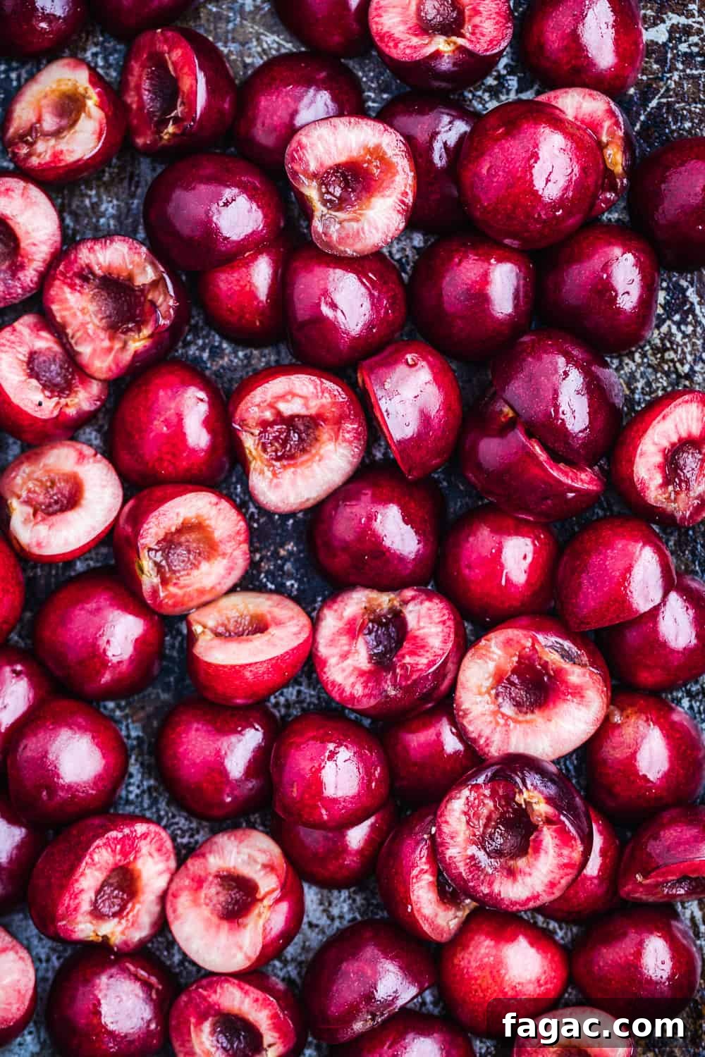 prep shot of raw cherries! the cherries are cut in half and on a tray, all ready to go in the oven.