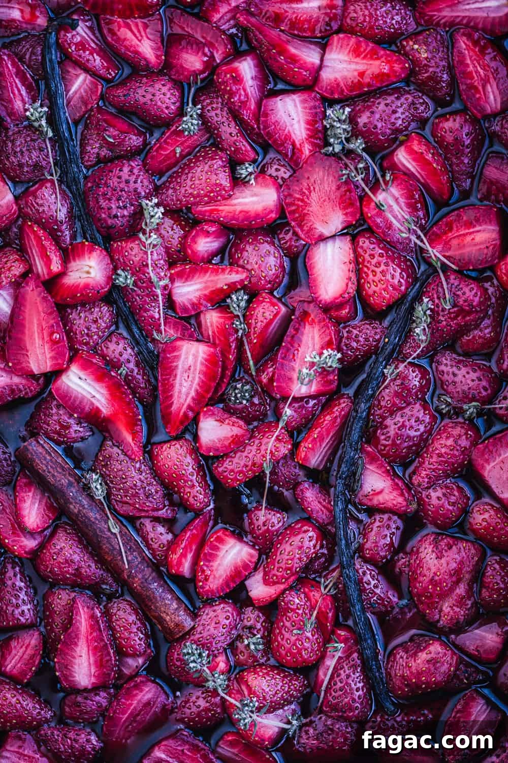 Cooked strawberries were roasted with thyme and vanilla just out of the oven, overhead shot.