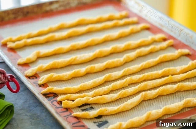 Cheddar Cheese Twists Recipe Cheese Twist Crackers - Lined up in Row on Sheet Pan