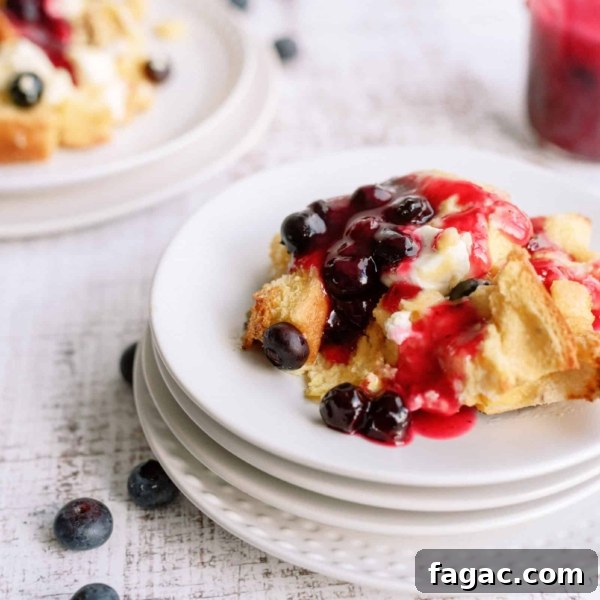 A slice of Overnight Blueberry French Toast on a plate with fresh blueberries.