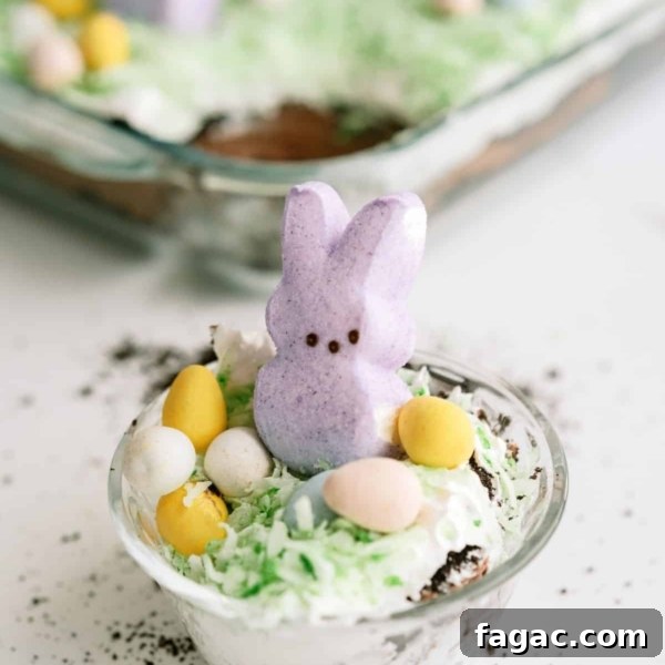 A serving of Easter Bunny Pudding Dirt Cake in a small plastic cup.