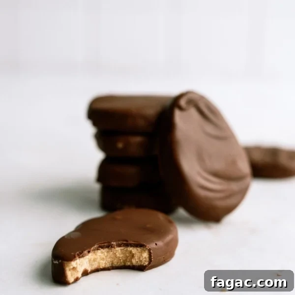Homemade Reese’s Eggs stacked with one of to the side with a bite missing.