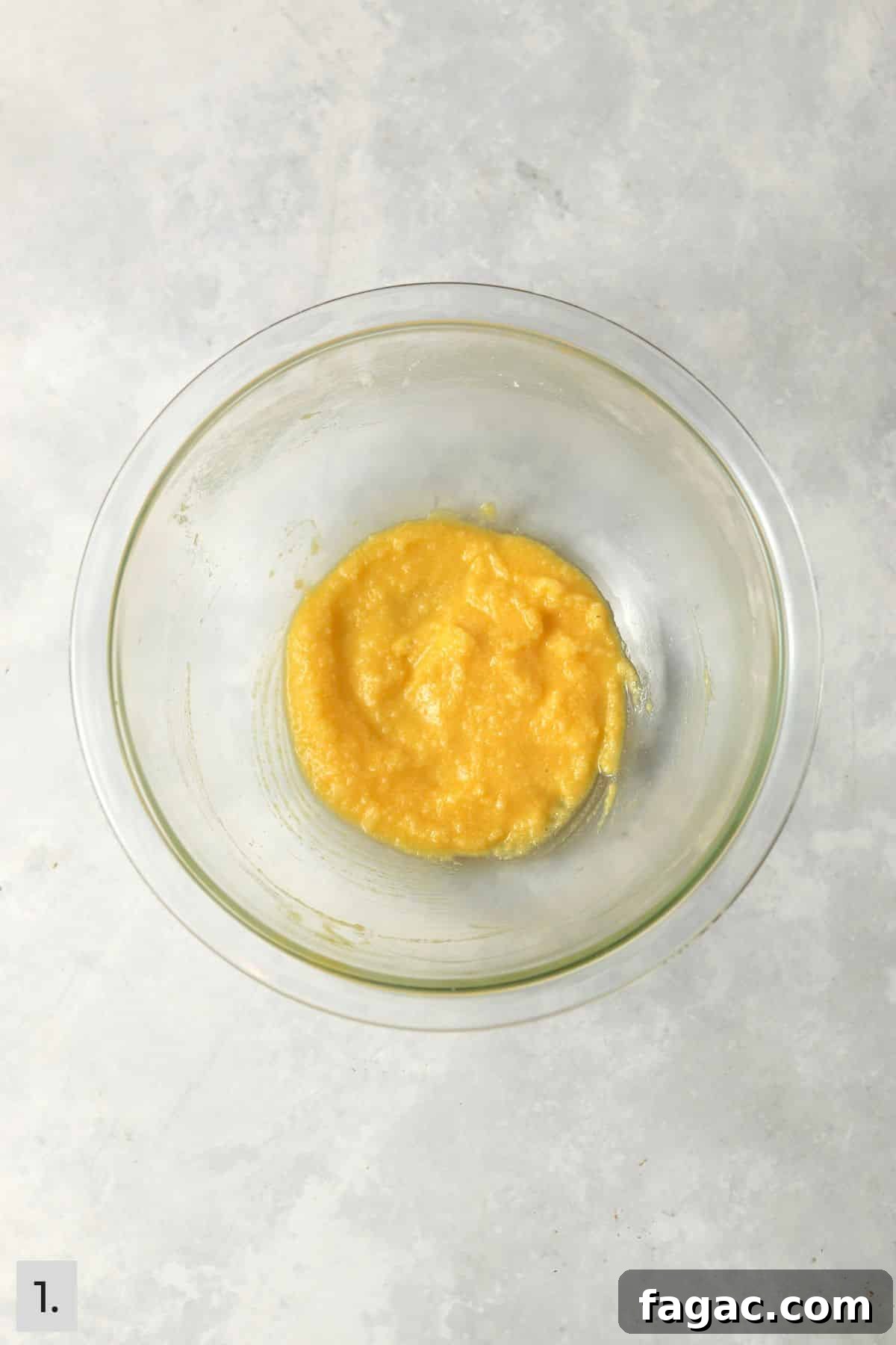 Butter, sugar, egg yolk, and vanilla mixed together in a glass bowl.