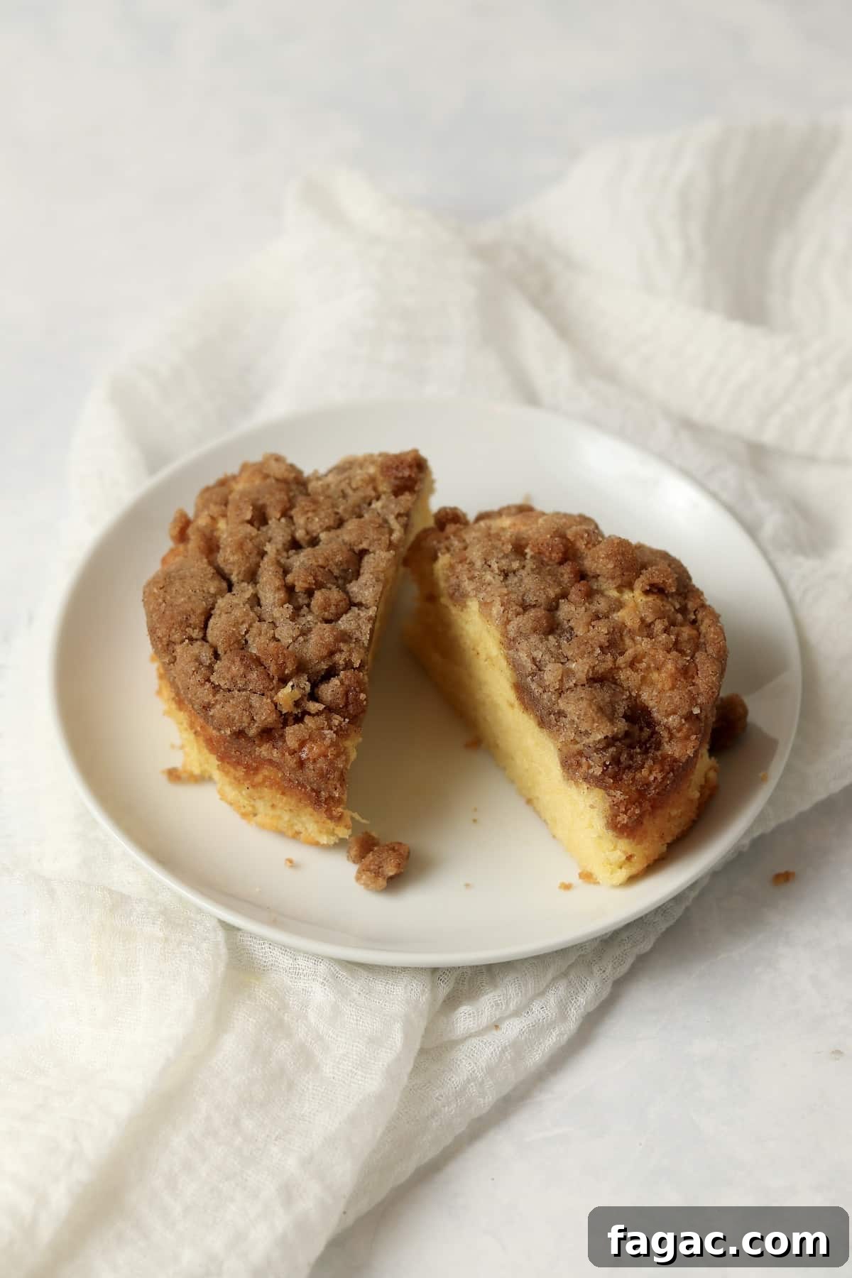 Small batch streusel coffee cake cut in half on a plate.