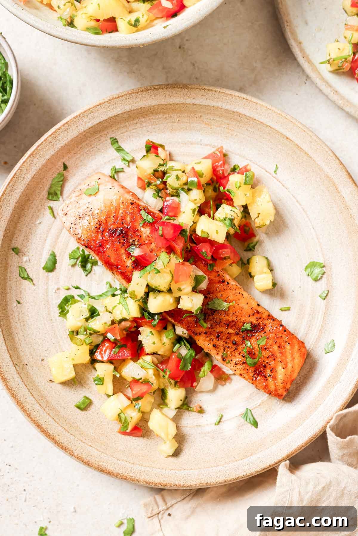 Crispy Pan-Seared Salmon with Fresh Pineapple Salsa 2 A plate of salmon with a pineapple salsa.
