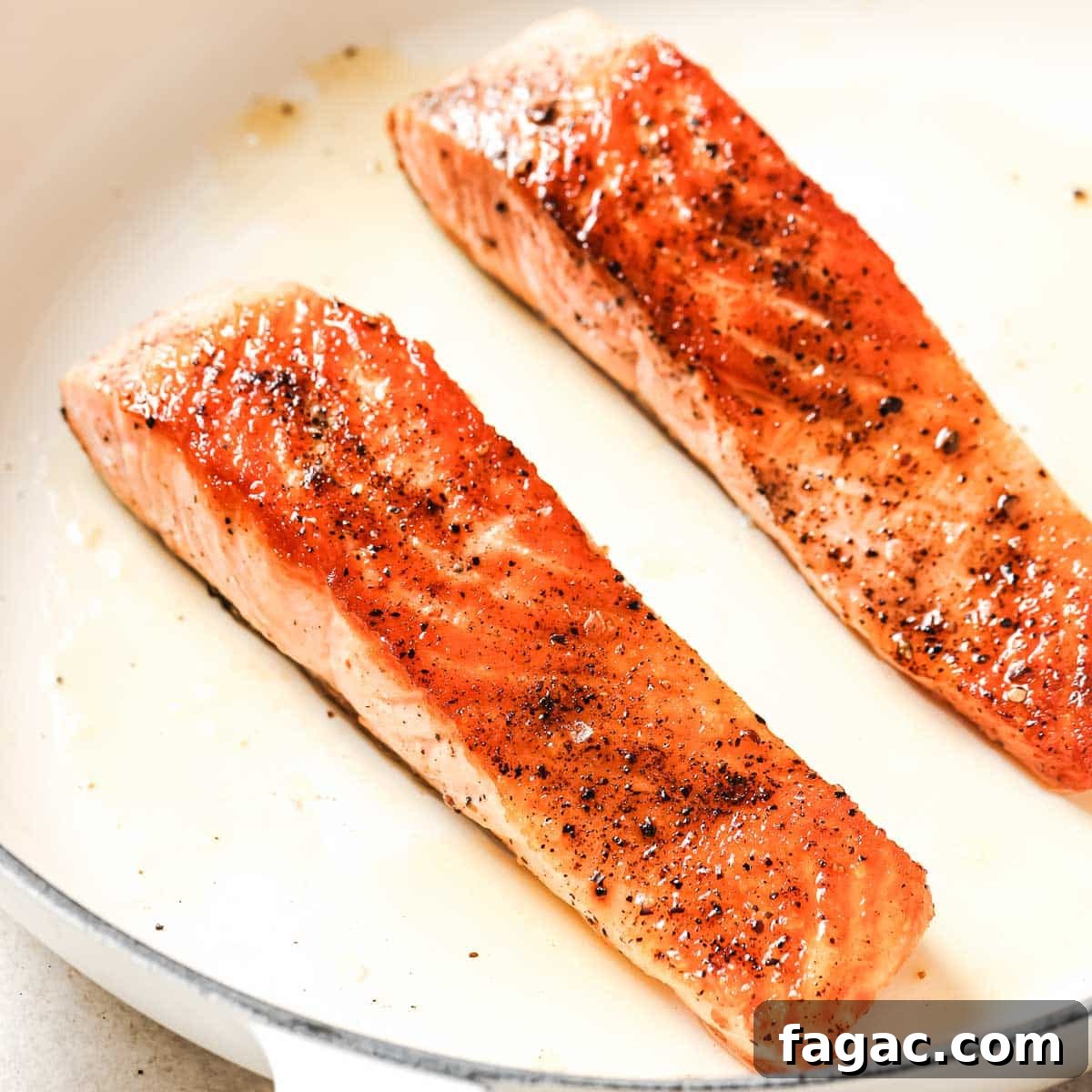 Crispy Pan-Seared Salmon with Fresh Pineapple Salsa 10 Two salmon fillets in a frying pan.