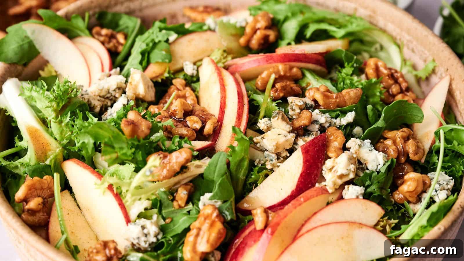 21 Easter Salad Ideas to Refresh Your Holiday Table 3 A bowl of mixed greens salad with sliced Honeycrisp apples, walnuts, and crumbled blue cheese.