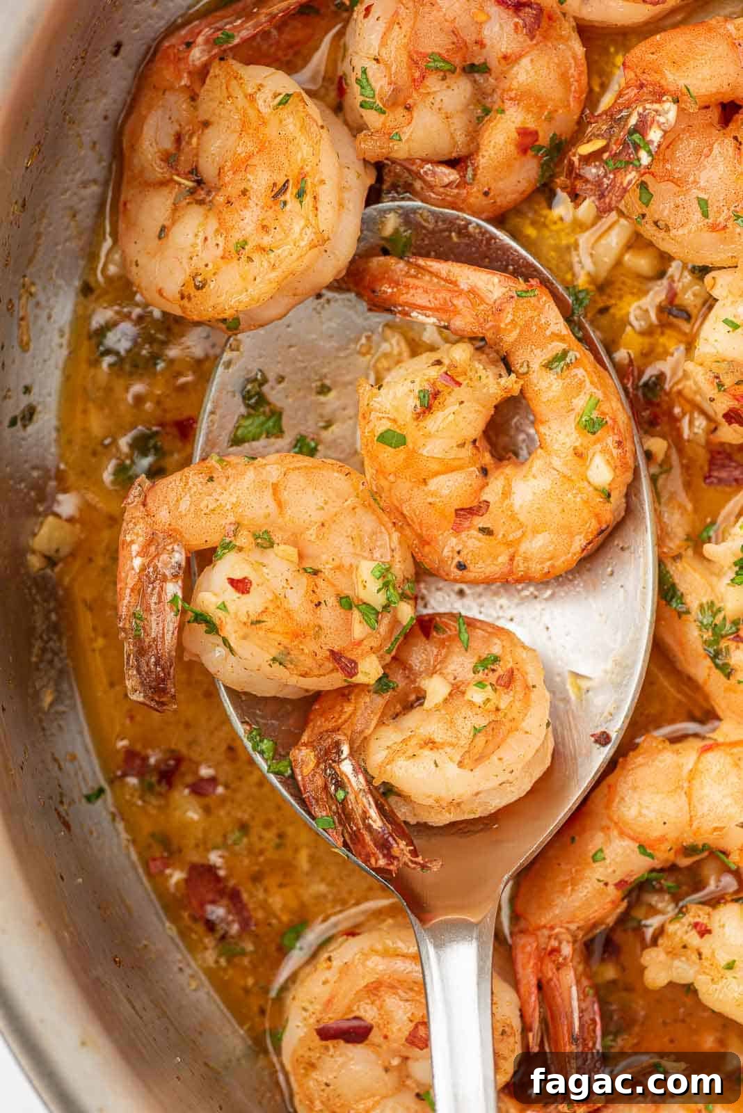 Closeup of a spoon with garlic and lemon shrimp.