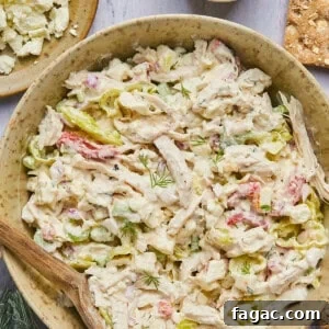 feta chicken salad in a bowl with a wooden spoon