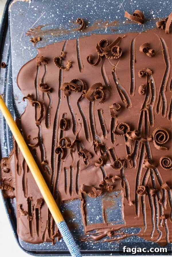 Chocolate spread onto a baking sheet, making chocolate curls.