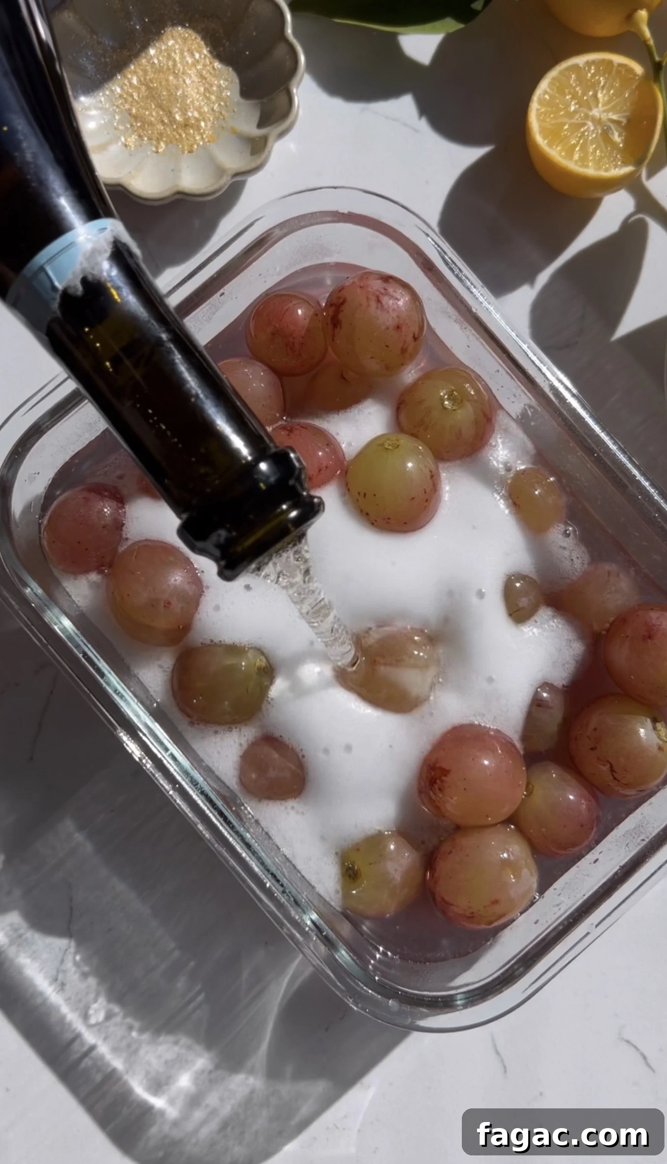 French 75 Grapes: Growing Guide and Wine Uses 4 Grapes soaking in champagne and gin in a glass dish with lemon and edible gold nearby.