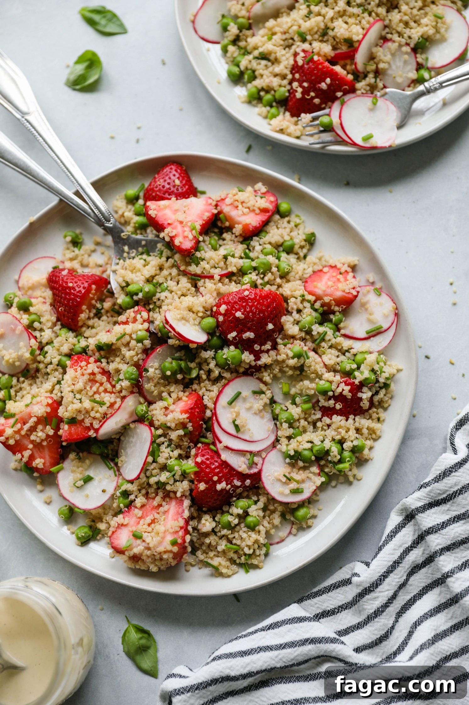 Fresh Strawberry Quinoa Salad with Lime Tahini Dressing 2 Strawberry Quinoa Salad served on plate with forks with blue and white striped towel with zesty lime tahini dressing