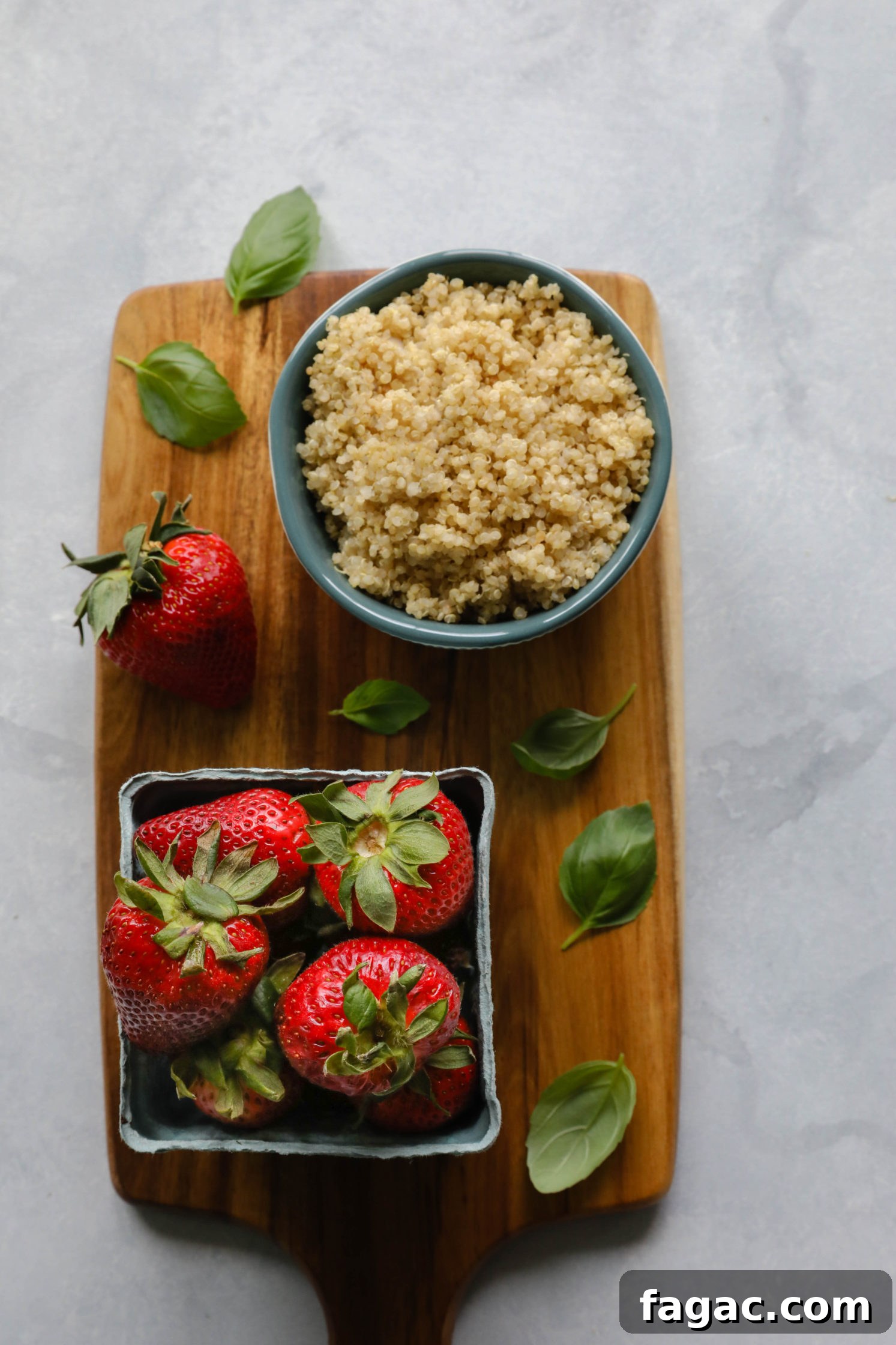Fresh Strawberry Quinoa Salad with Lime Tahini Dressing 5 quinoa in bowl with fresh strawberries and basil leaves on wooden board